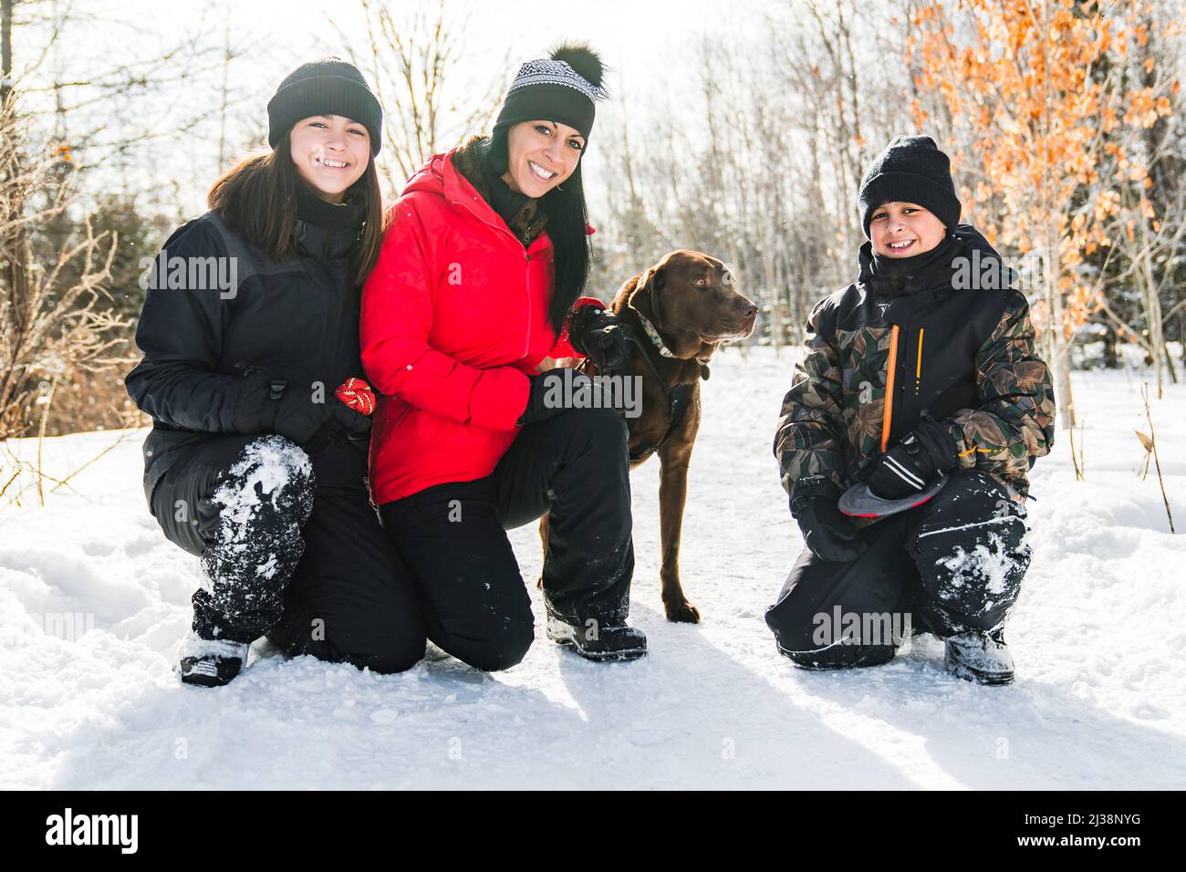 Portrait of family with labrador dog in winter season Stock Photo