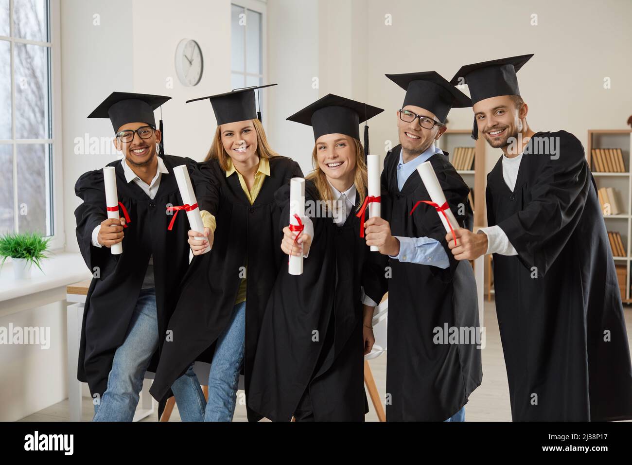 Portrait of diverse graduates with diplomas certificates Stock Photo