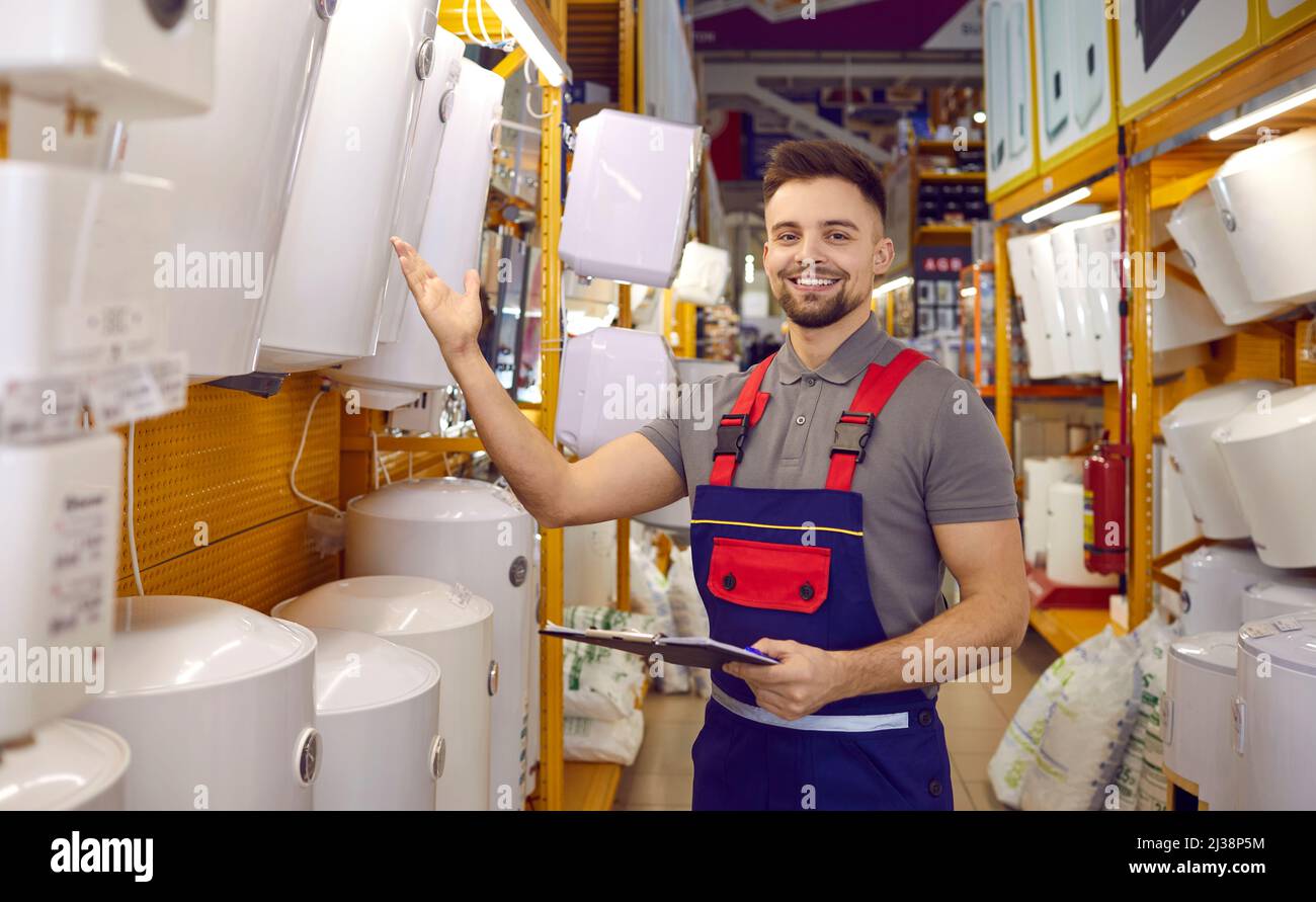 Friendly seller demonstrates wide range of thermodynamic boilers and wall-mounted water heaters. Stock Photo