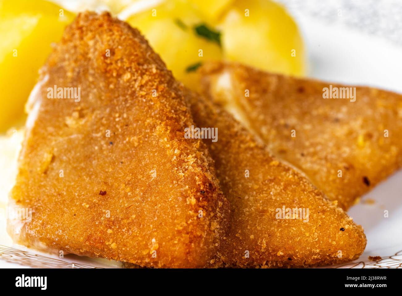 Three piece of fried breaded cheese with potato on plate, closeup. Traditional and favourite food in czech republic. Stock Photo
