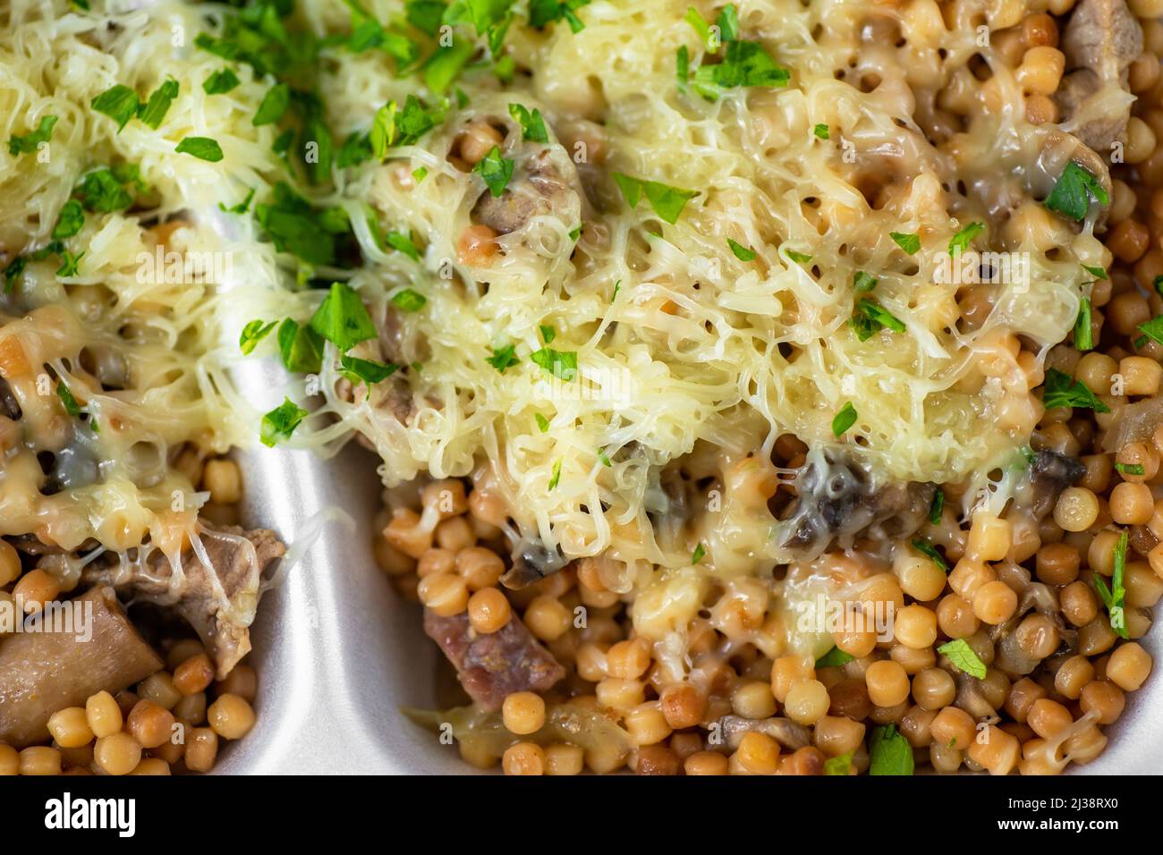 Round semolina pasta with sliced pork meat, sauce, mushroom and grated