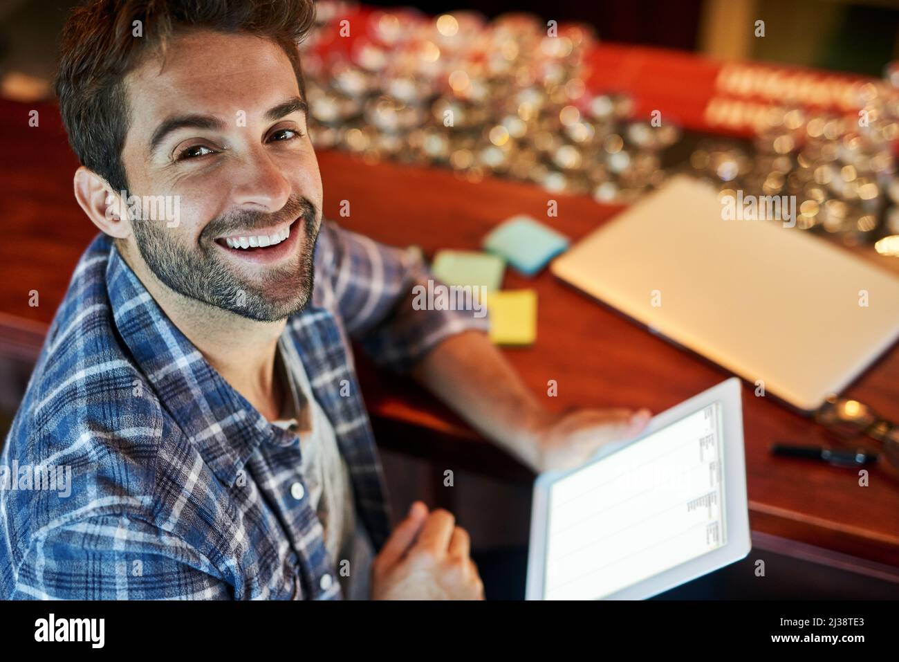 This cafe has some fast internet. Portrait of a handsome young man sitting in a cafe using a digital tablet. Stock Photo