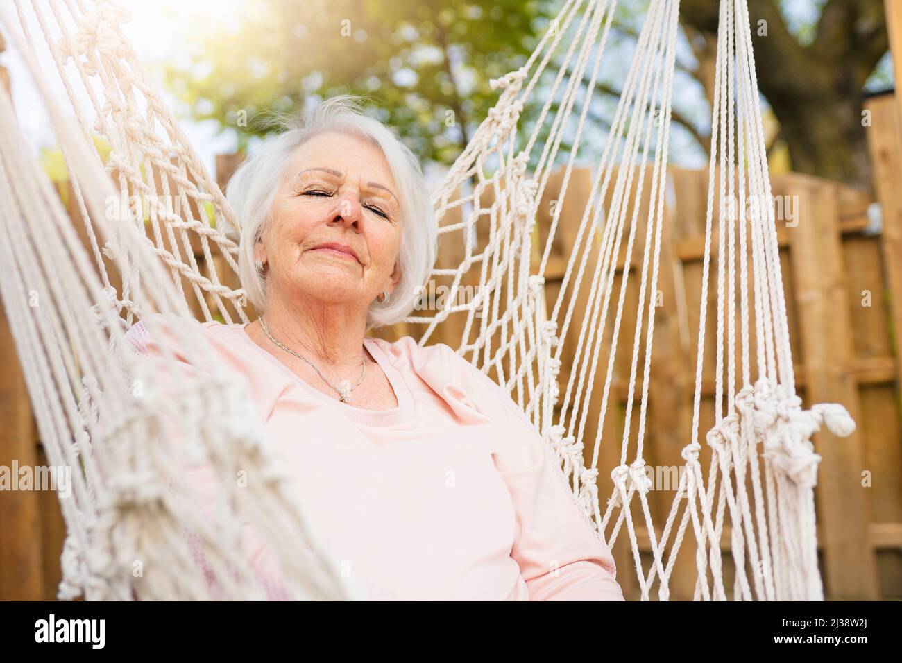 The senior woman relaxing in a hammock Stock Photo - Alamy