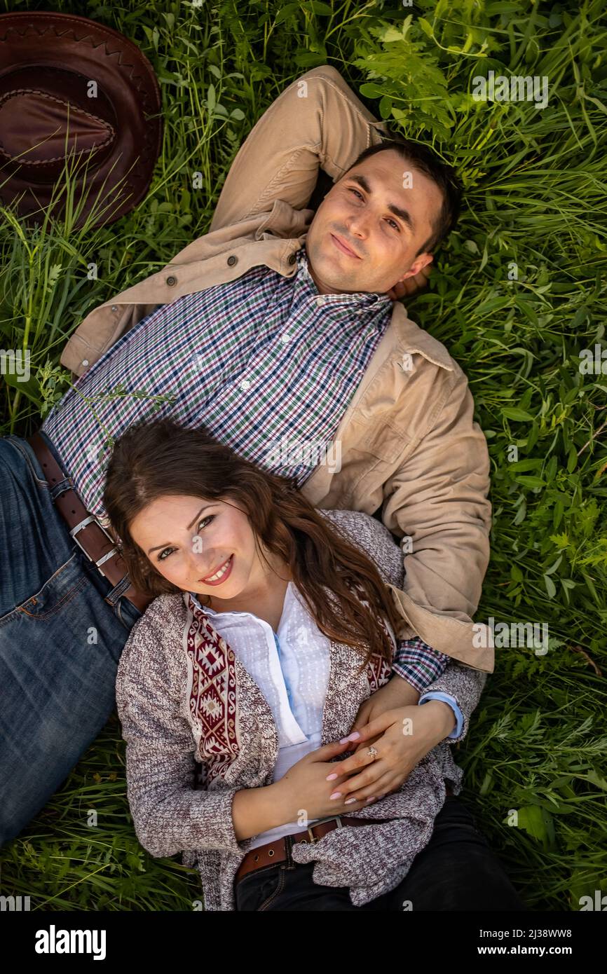 happy stylish couple lying in green grass Stock Photo - Alamy