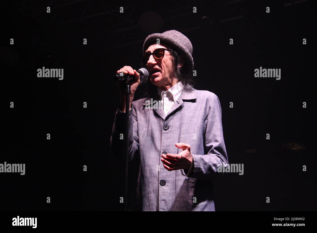 Salford-born comedian Dr John Cooper Clarke performing on stage at the Raise The Roof fundraising event at Victoria Warehouse, Manchester Stock Photo