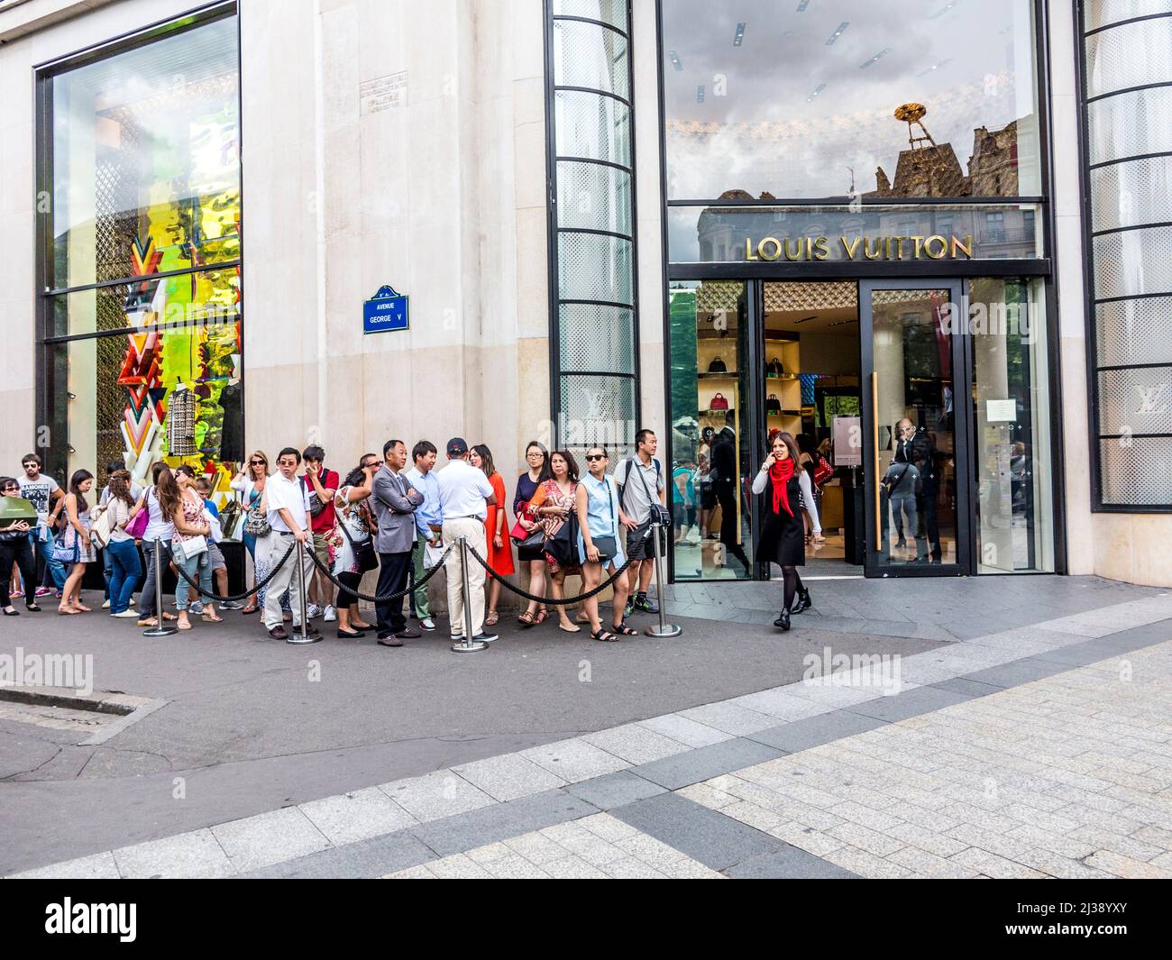 PARIS, FRANCE - JUNE 12, 2015: people queue up in front of Louis Vuitton shop at champs elysees for shopping. Stock Photo