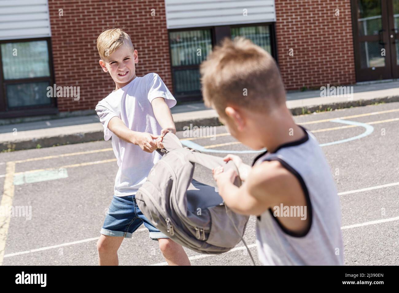 Cruel teenagers punching younger boy, physical intimidation, school bullying Stock Photo