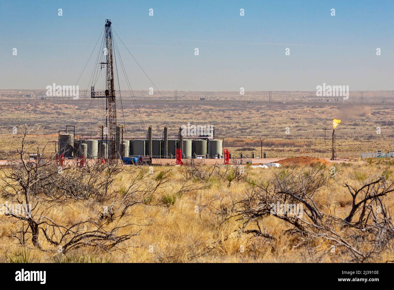 Loving, New Mexico - An oil drilling rig and oil storage tanks in the Permian Basin. The Permian Basin is a major oil and gas producing are. Stock Photo