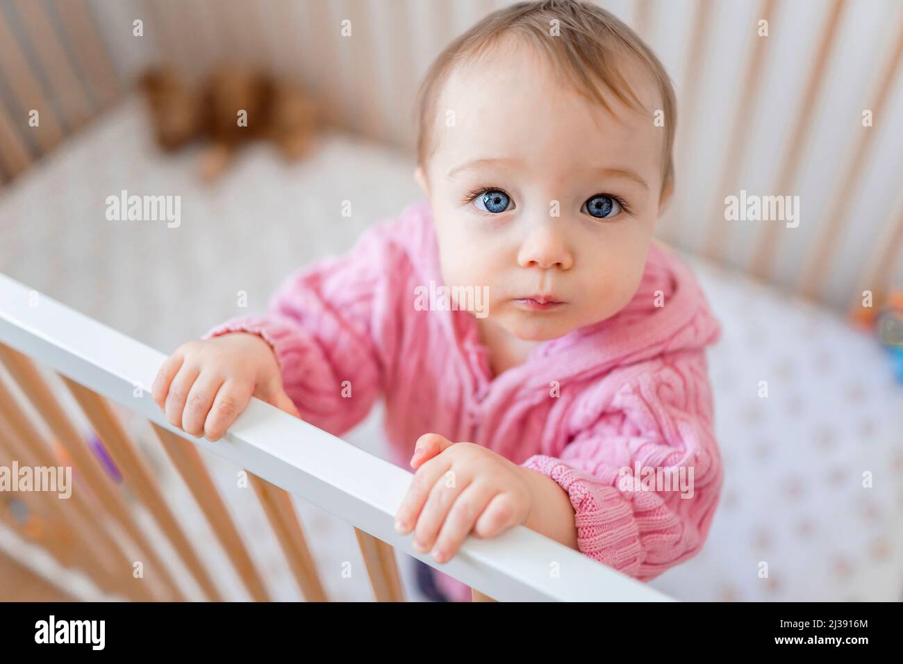 baby standing in crib in the nursery Stock Photo Alamy