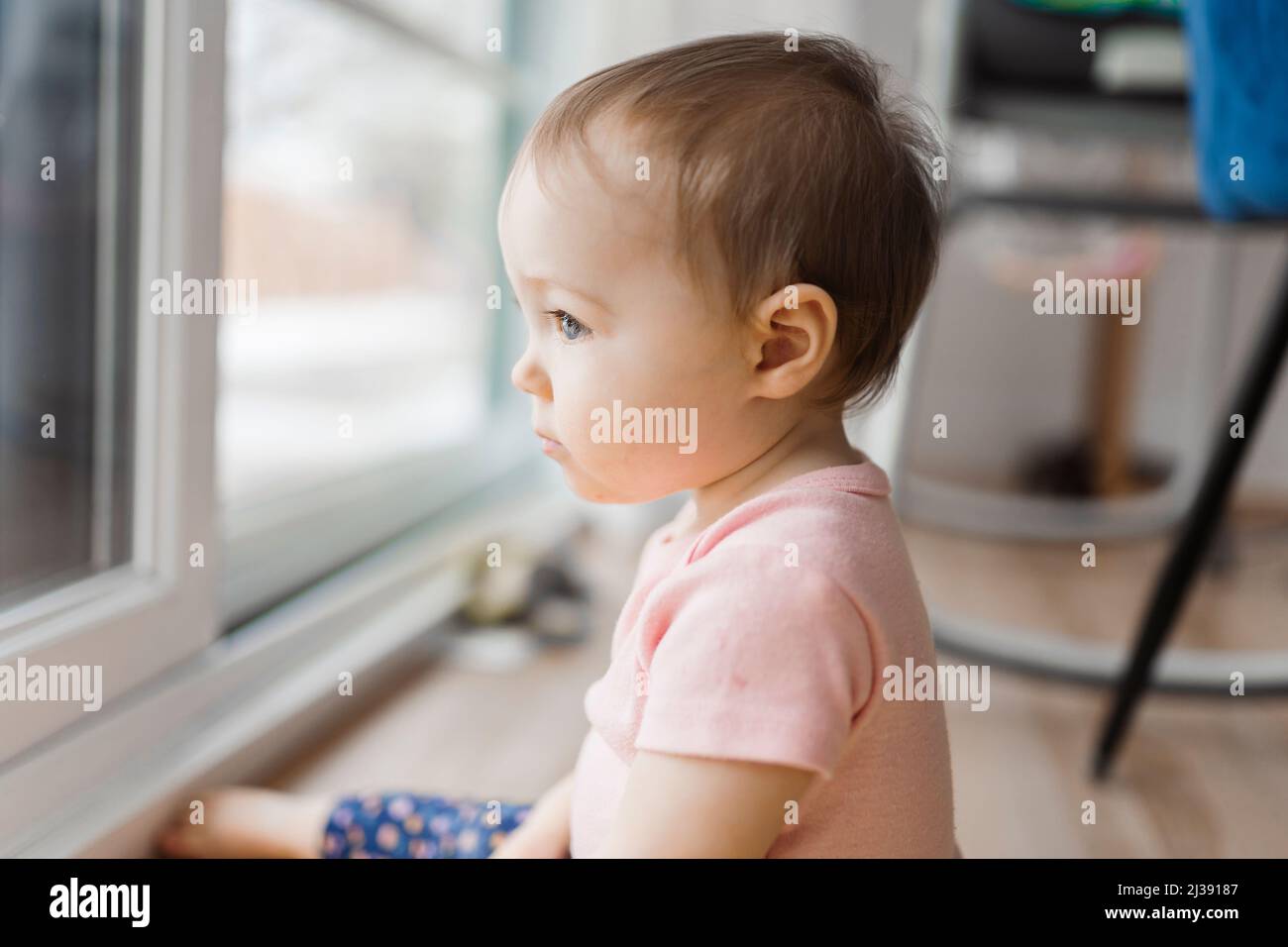 cute and Adorable girl look through window outside Stock Photo