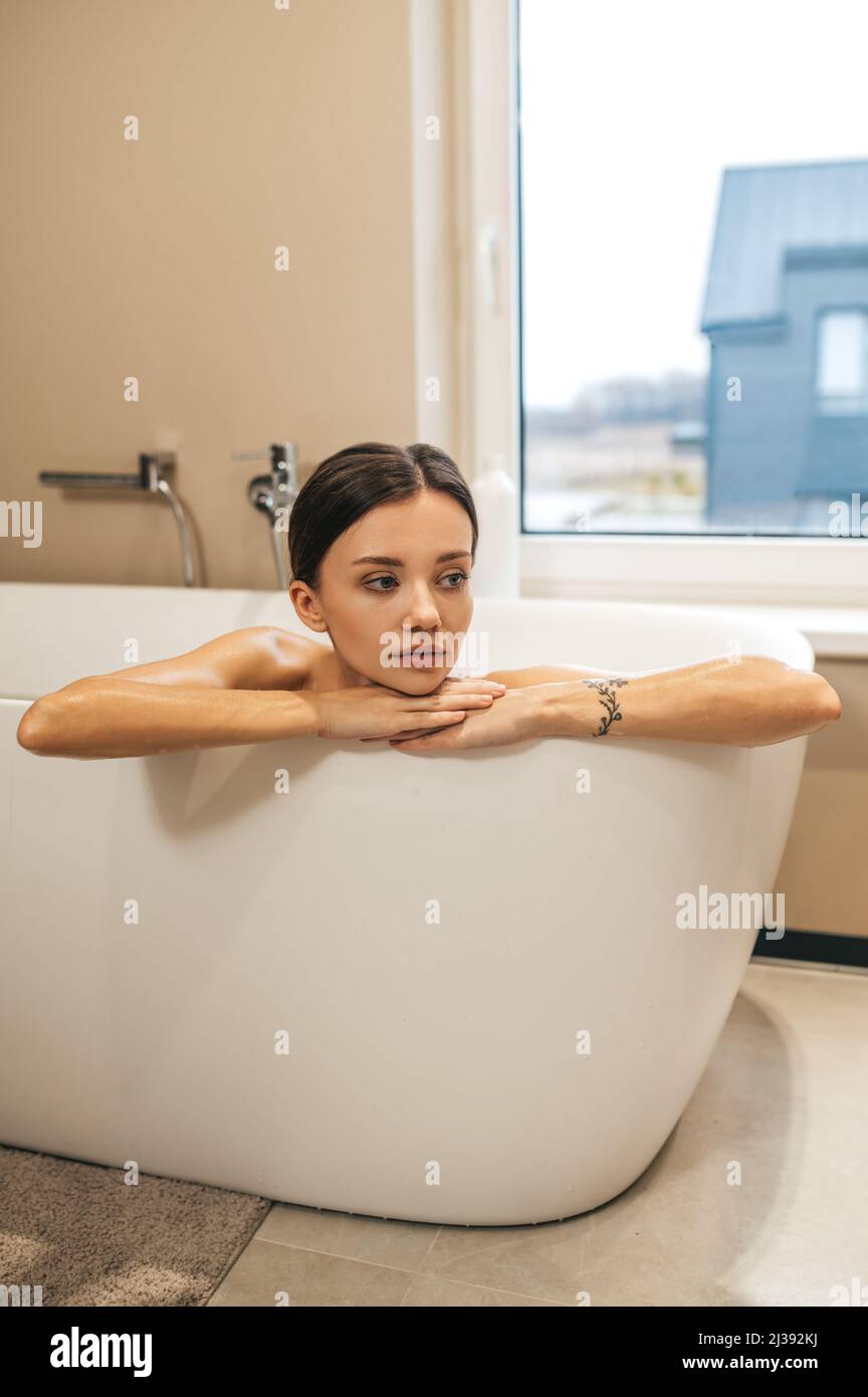Low-spirited thoughtful woman sitting in the bath Stock Photo