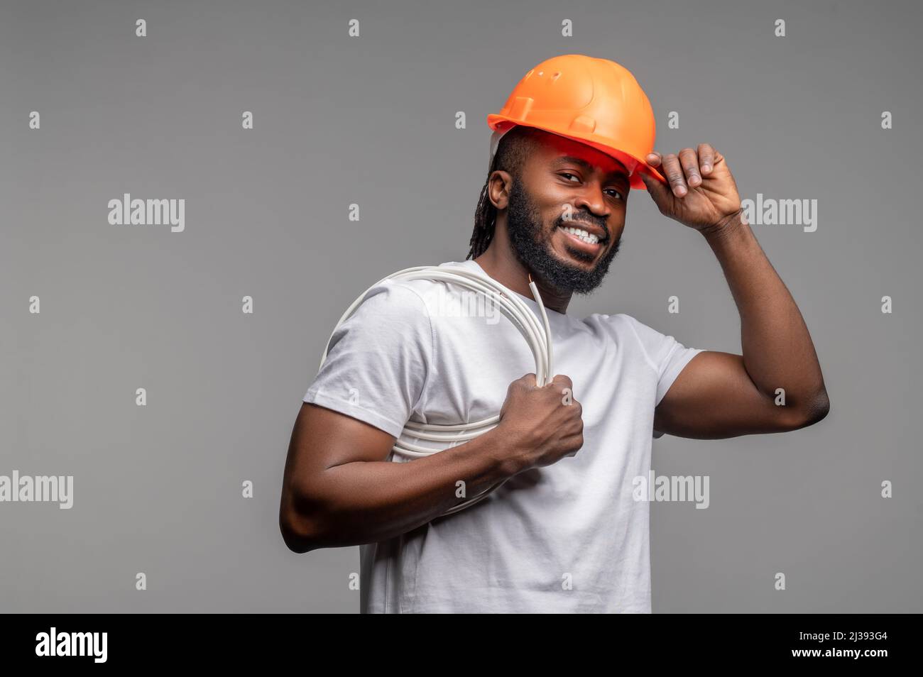 Builder with a wrapped power cable over his shoulder Stock Photo
