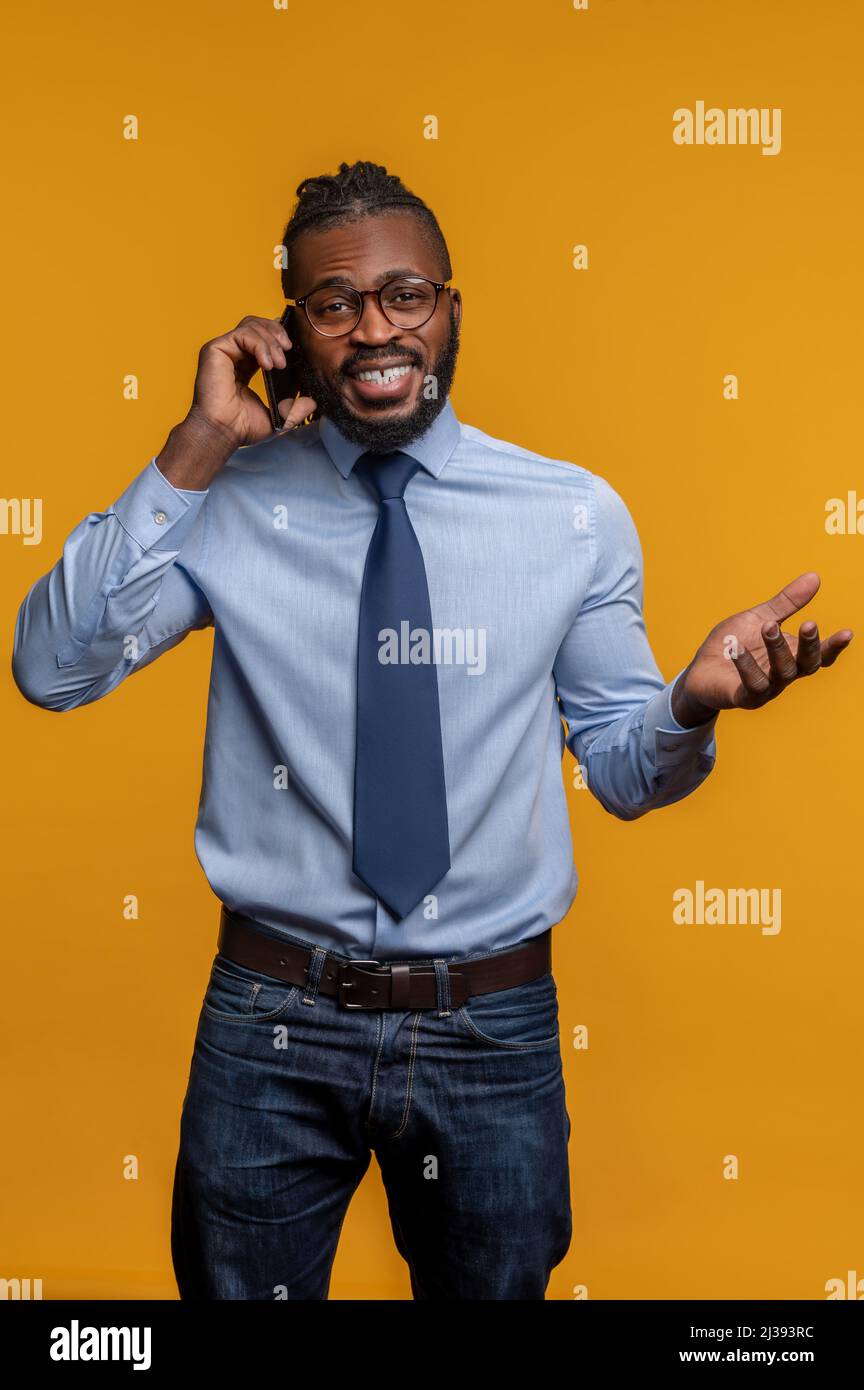 Joyous businessman gesticulating during the phone conversation Stock Photo