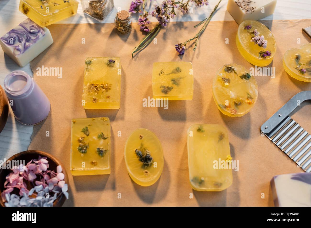 Top view of handmade soap bars on craft paper near dry flowers and
