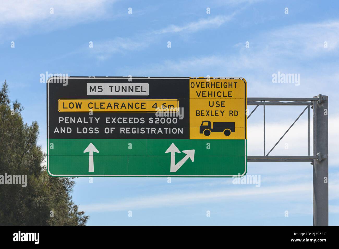 A low clearance sign ahead of the tunnel on the M5 motorway in Sydney Stock Photo