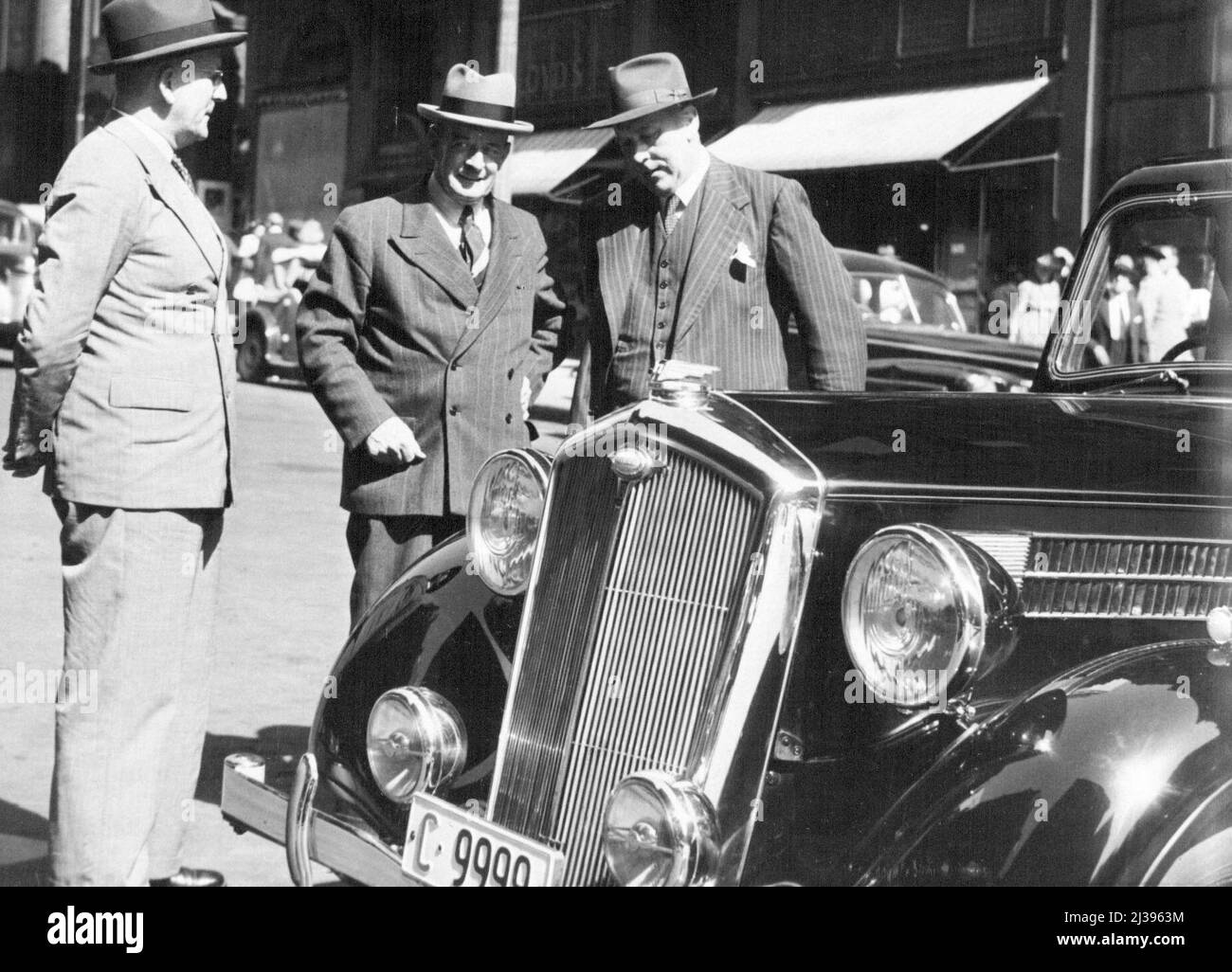 This New English car, latest 18-85 horse - power Wolseley, being presented in Martin-place to Mr. H. T. Armitage, Governor of the Commonwealth Bank, by Mr. G. A. Lloyd, Managing Director Nuffields Australia Pty., Ltd. On the left is Mr. Sheehan, Deputy - Governor, Commonwealth Bank. January 31, 1945. Stock Photo