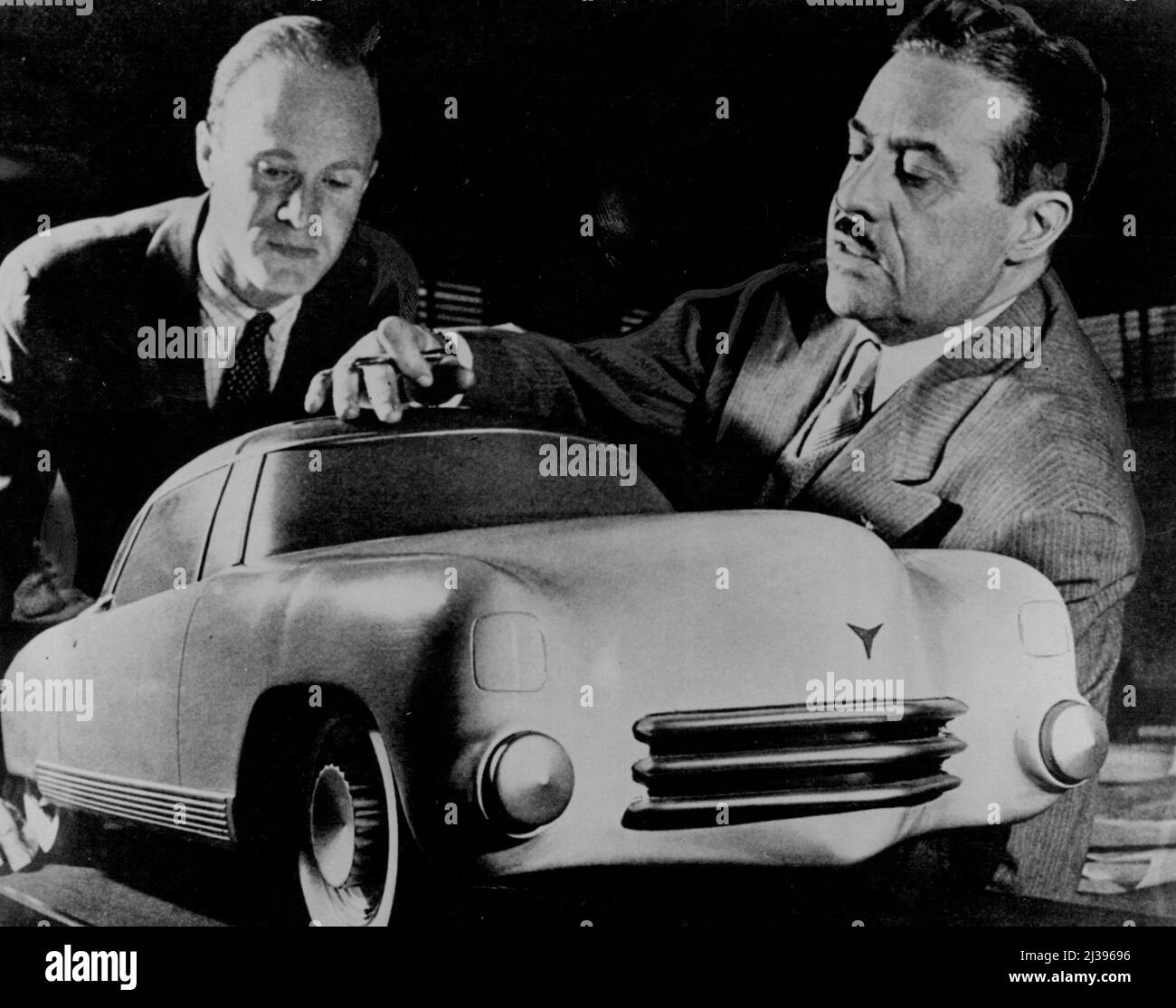 Raymond Loewy, U.S. designer (right), discusses his car of the