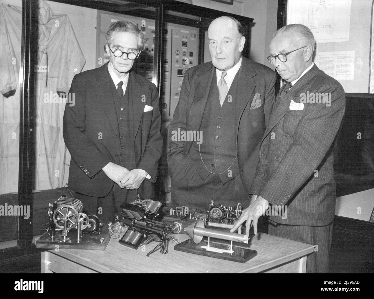 Control Of World's First Guided Missile (British) Handed Over To Museum -- Sean at the presentation ceremony this morning at the ImperiaL War Muse am are (left to right) Professor A.M. Low; Lord Brabazon of Tara; and Mr. Bradley Director General of the Museum. On the table in front of them are early patents of guided missiles etc. which were also on view today. Professor A.M. Low, the research physicist, today handed over to the imperial War Museum, Lambeth Road, Southwark (London) the control gear of the world's first guided missile. Tired of hearing that various other countries were first Stock Photo