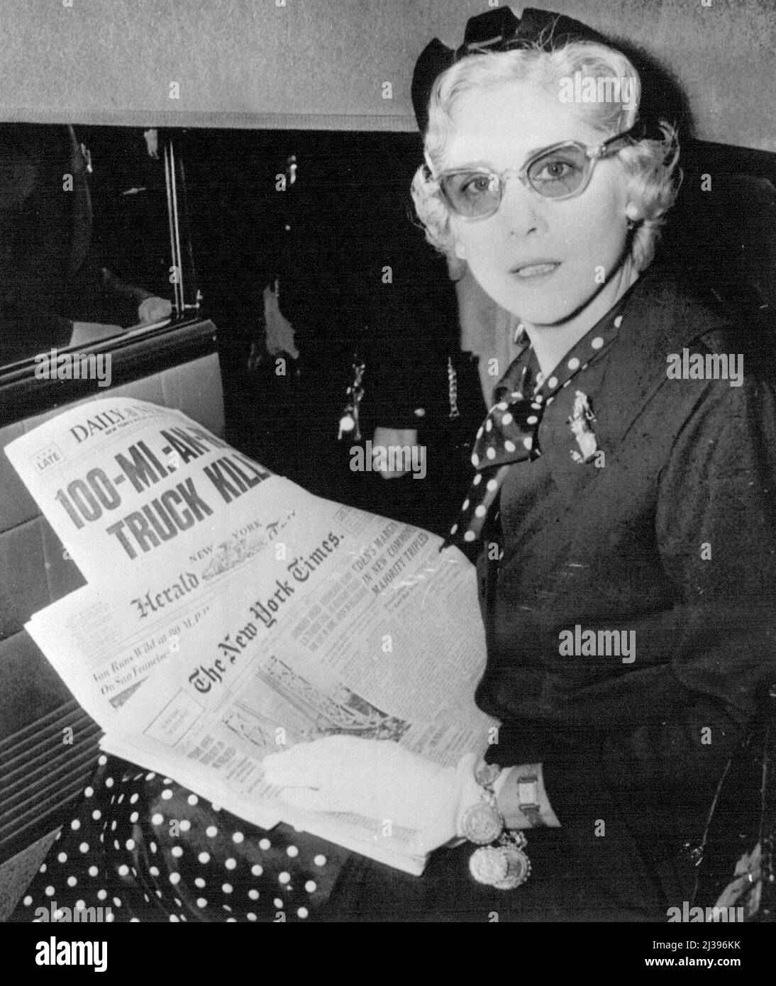 Catching Up With The News - Clare Boothe Luce, U.S. Ambassador to Italy, scans headlines of newspapers in limousine at International Airport today shortly after arrival from Rome. She said she wanted to 'deny the many rumours that she will succeed Mrs. Oveta Culp Hobby as Secretary of Health, Education and Welfare,' and added she had returned for a summer vacation. May 28, 1955. (Photo by AP Wirephoto). Stock Photo