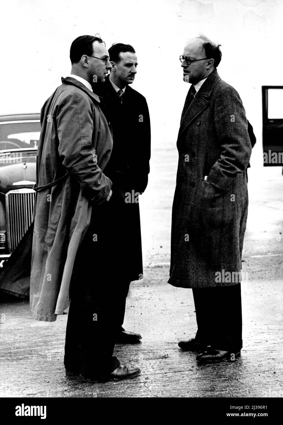 28 Dead In Air Liner Crash: Experts Visit London Airport -- Minister of Civil Aviation Lord Pakenham (right) discusses the accident with Sir John D'Albiac, Commandent of London Airport and Capt. J.G. James, Chief Pilot of B.E.A. (in blue mac) this morning at London Airport. Only two out of the 30 people on board survived when a British European Airways "Viking" aircraft crashed while attempting to land at London Air Port in dense fog last night (Tuesday). The plane overshot the runway and hit a stack of drainage pipes. This morning Ministry of Civil Aviation experts visited the scene of the Stock Photo