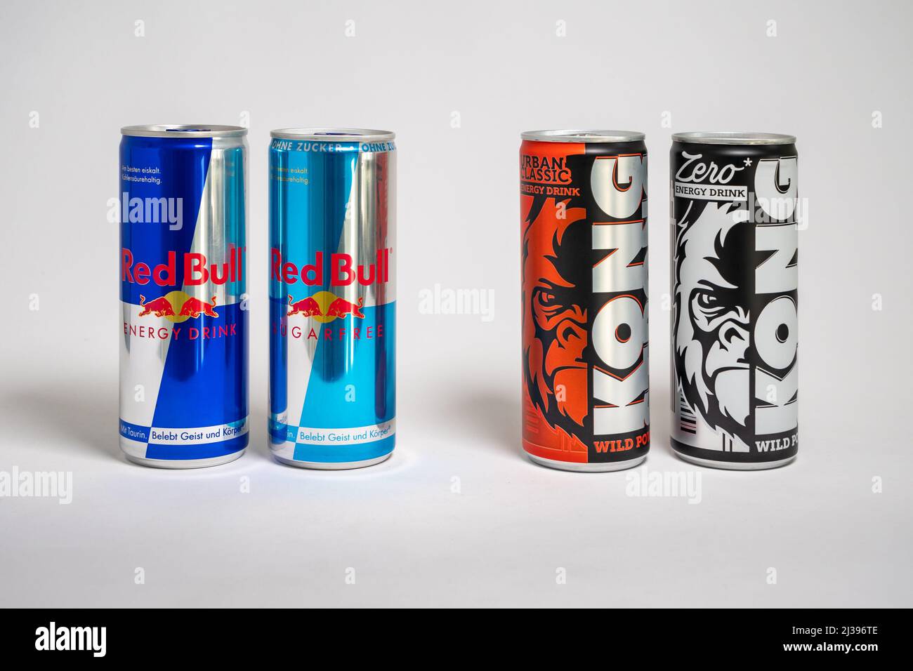 Red Bull energy drink versus Lidl store brand Kong Strong. Beverages with sugar and sugar free as competition in the supermarket. Stock Photo