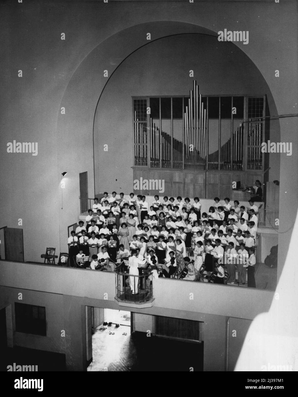 Out Of The Ashes (Fifth Of Nine) -- A choir rehearses for the dedication ceremony, which was held August 6th, the ninth anniversary of Hiroshima's 'Hell Day'. Note shoes left in Doorway (bottom). Citizens of Cologne, West Germany, donated the organ. August 13, 1954. (Photo by United Press). Stock Photo