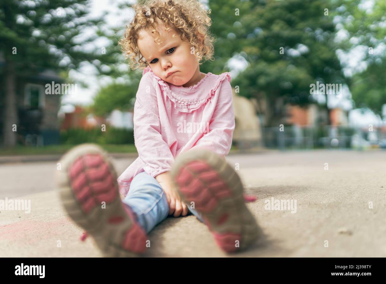 Young girl sitting on the floor at the school playground Stock Photo ...