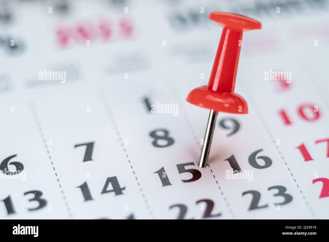 Red push pin on calendar 15th day of the month, mark the Event day with a Pin. Pin on calendar day fifteen, date number 15. Fifteenth day of the month Stock Photo