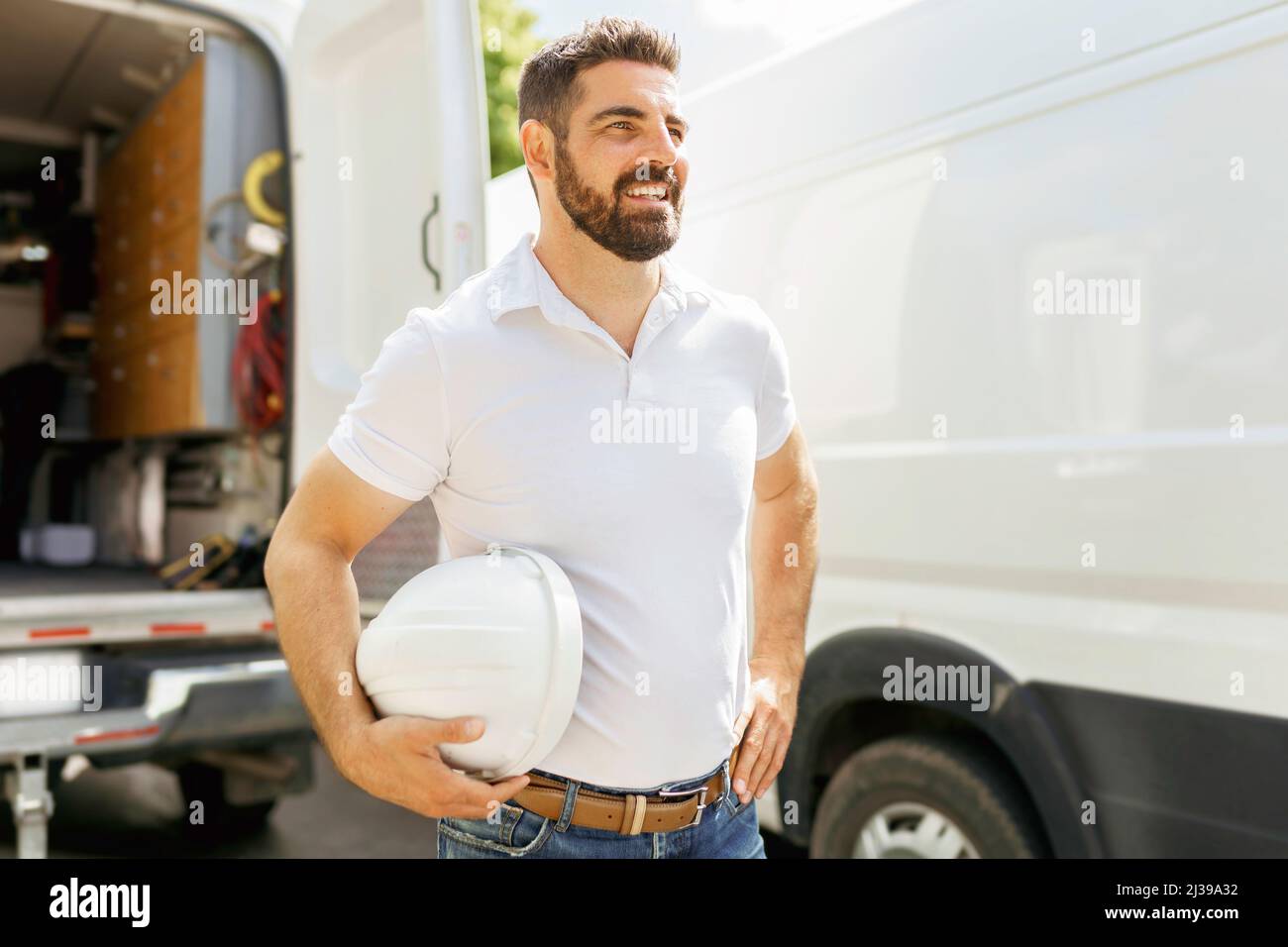 man with a hard hat standing in front of truck Stock Photo