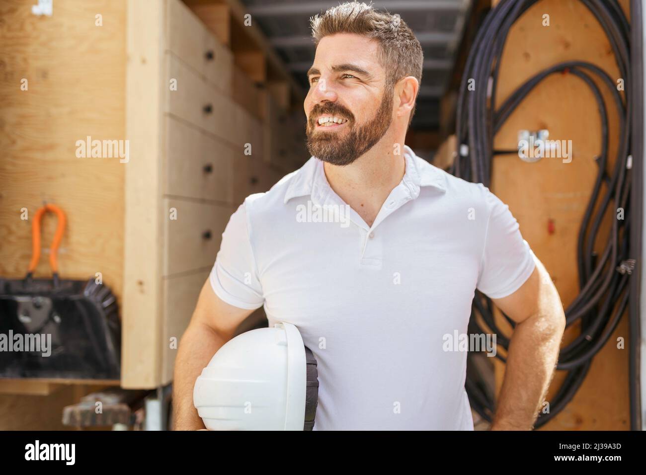 man with a hard hat standing in front of truck Stock Photo