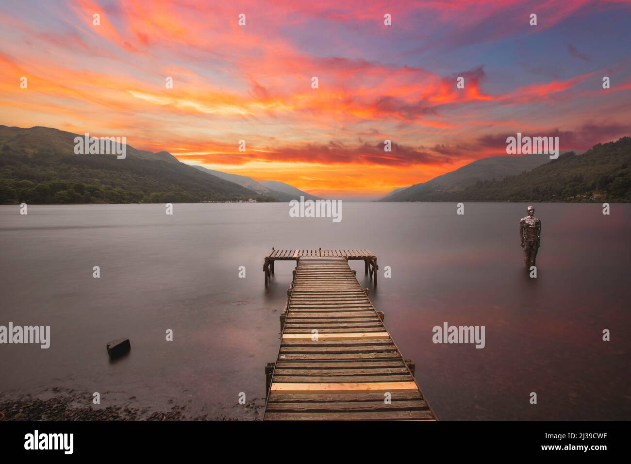 STILL, a seasonal installation by Rob Mulholland, stands among the waves during amazing sunset in Loch Earn, Perthshire, Scotland. ST FILLANS Stock Photo