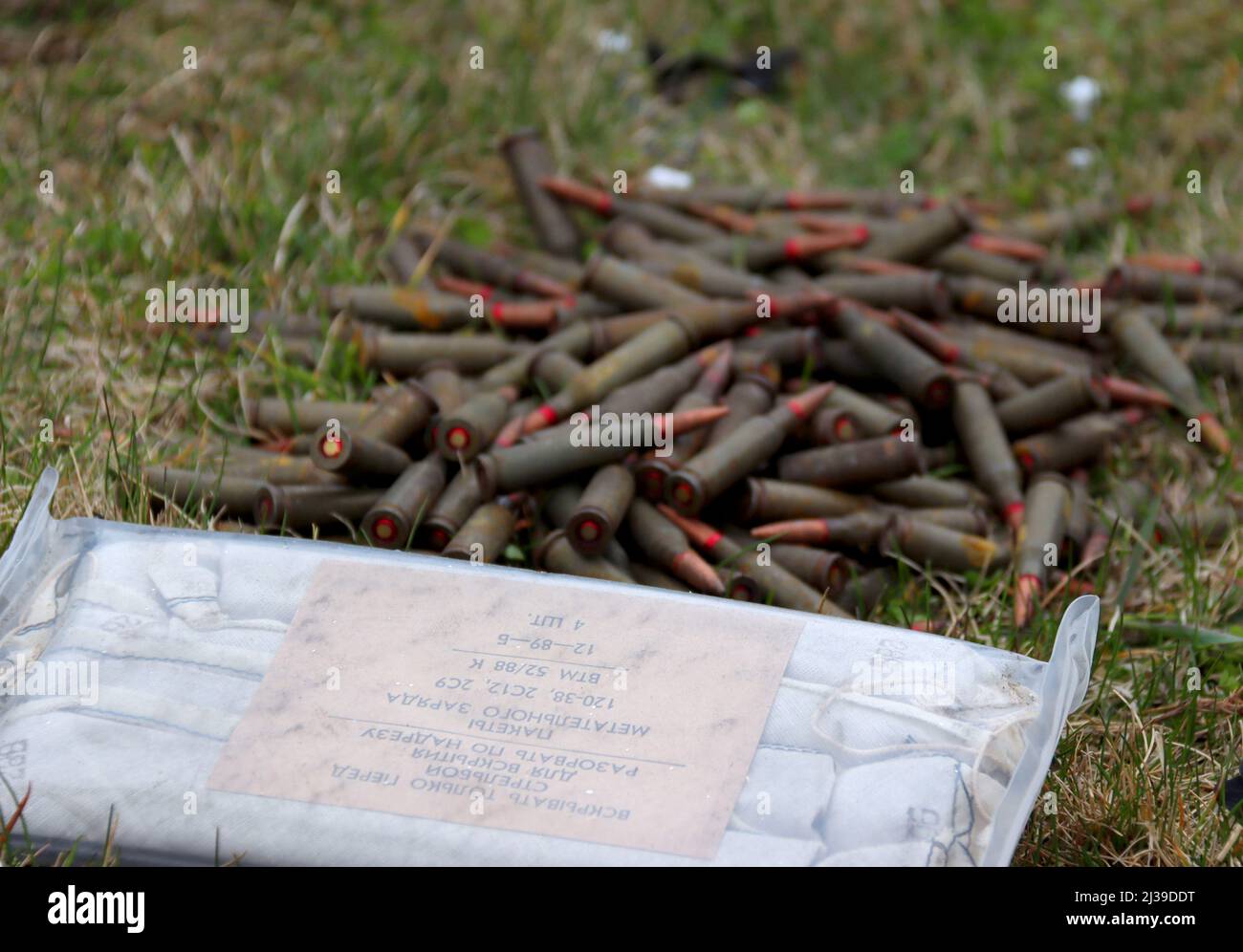 BUCHA, UKRAINE - APRIL 5, 2022 - Ammunition and a package of propellant left behind by Russian invanders are gathered on the ground in liberated Bucha Stock Photo