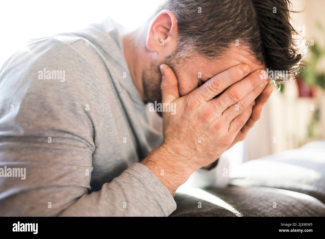 Depressed man at home on couch look sad Stock Photo