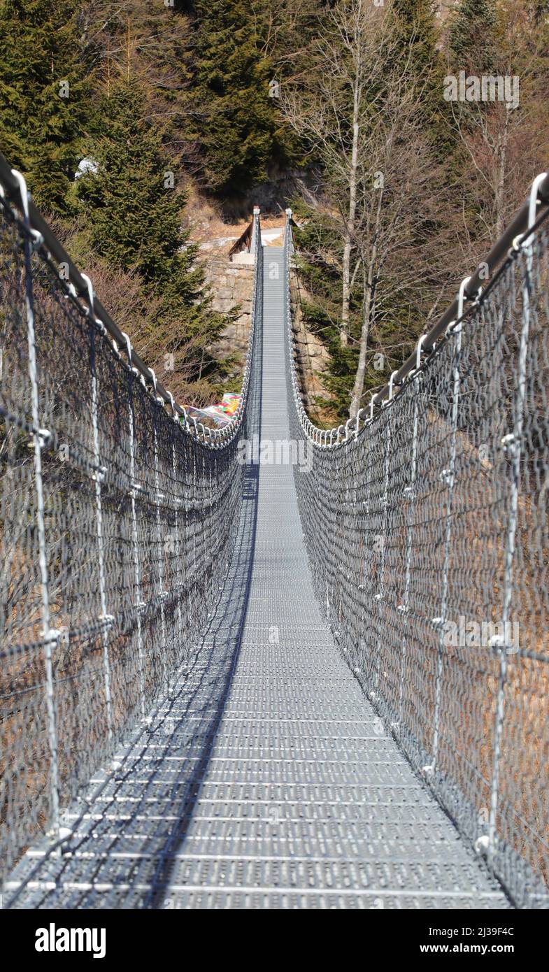 long suspension bridge called Tibetan bridge made with sturdy steel cables to connect the two mountain ridges without people Stock Photo