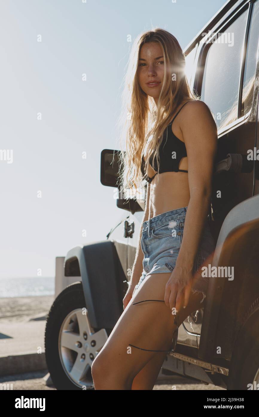 surfer girl sitting at a car in Malibu. On film California Stock Photo