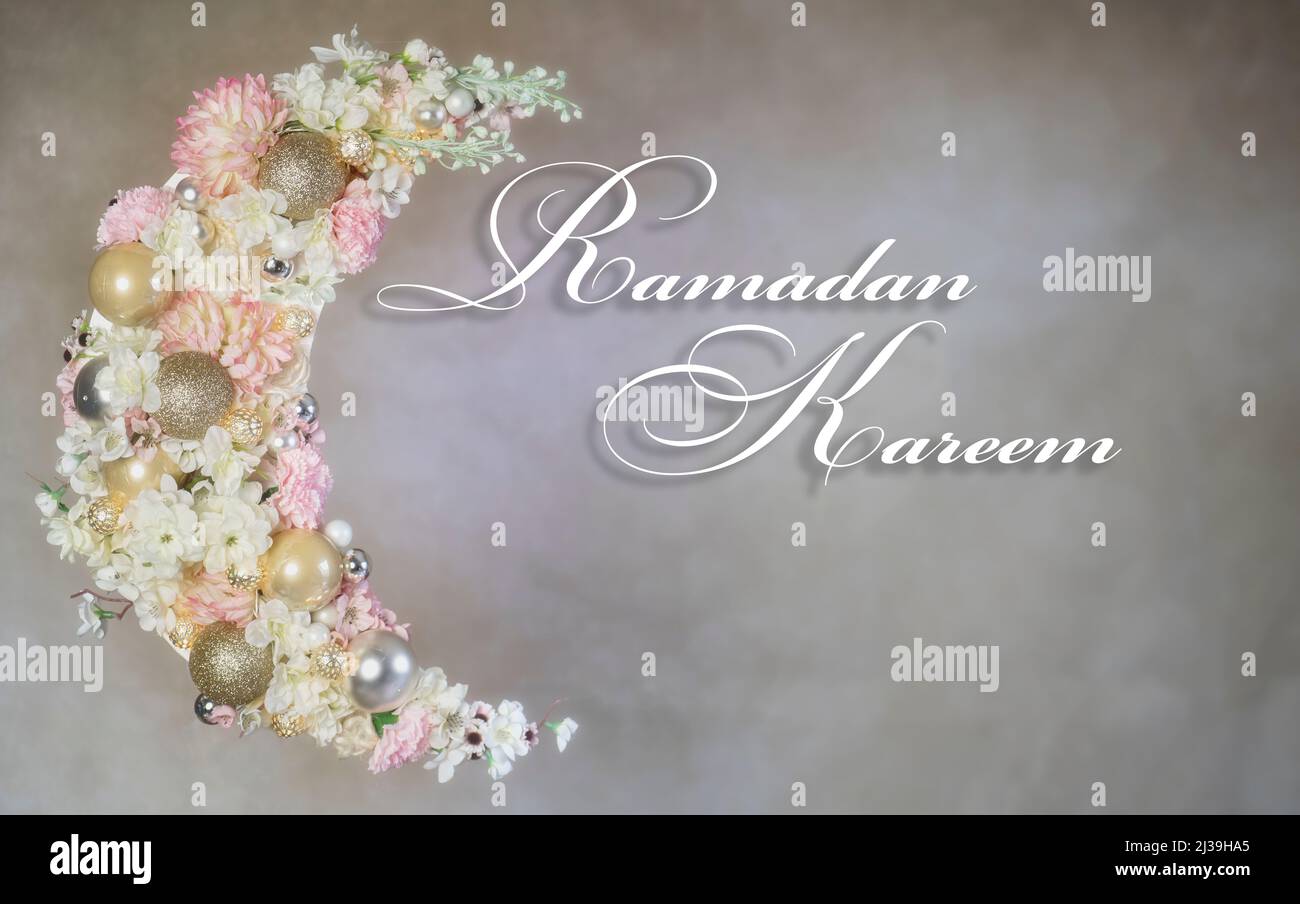 Ramadan Mubarak writing and crescent of Ramadan covered with flowers and lit up. Stock Photo