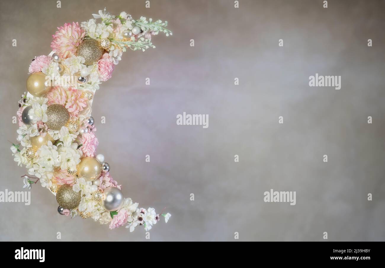 Crescent of Ramadan covered with flowers and lit up. Stock Photo