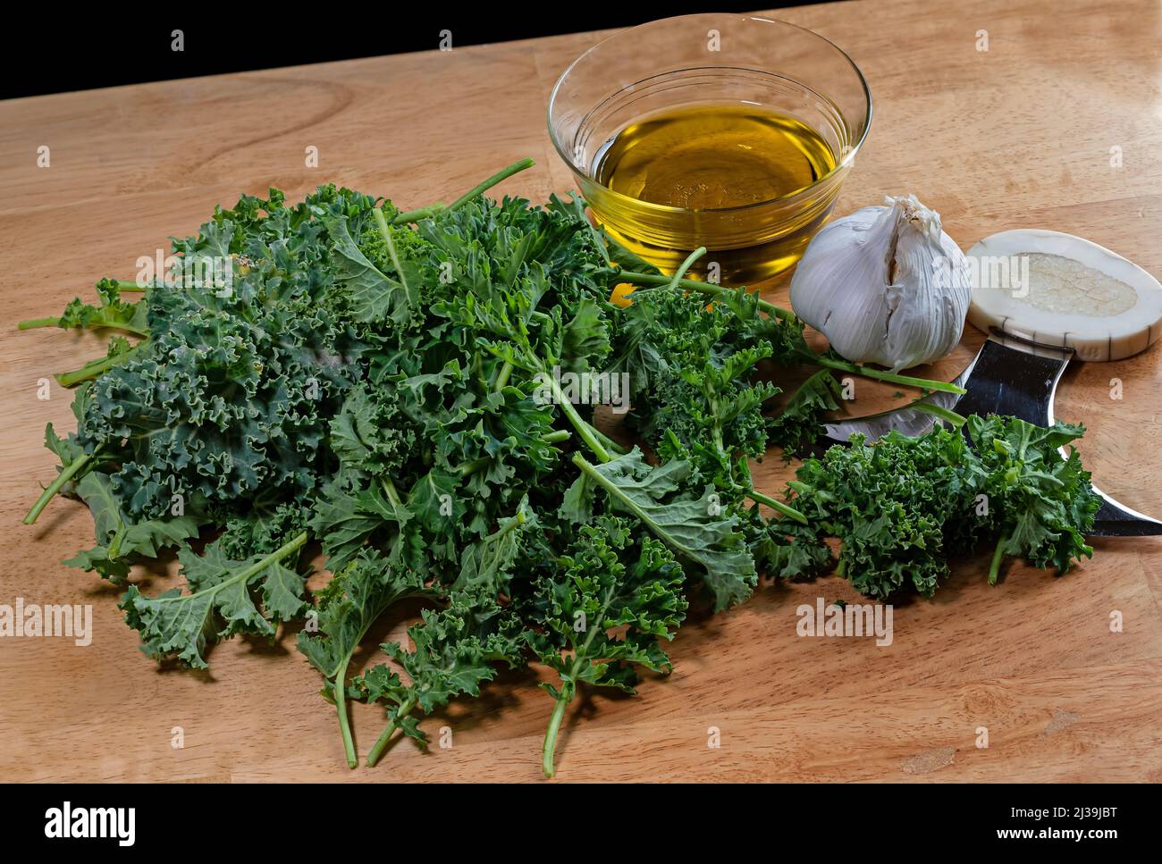 Fresh early springtime kale from the garden to be cooked with fresh garlic and olive oil. Stock Photo