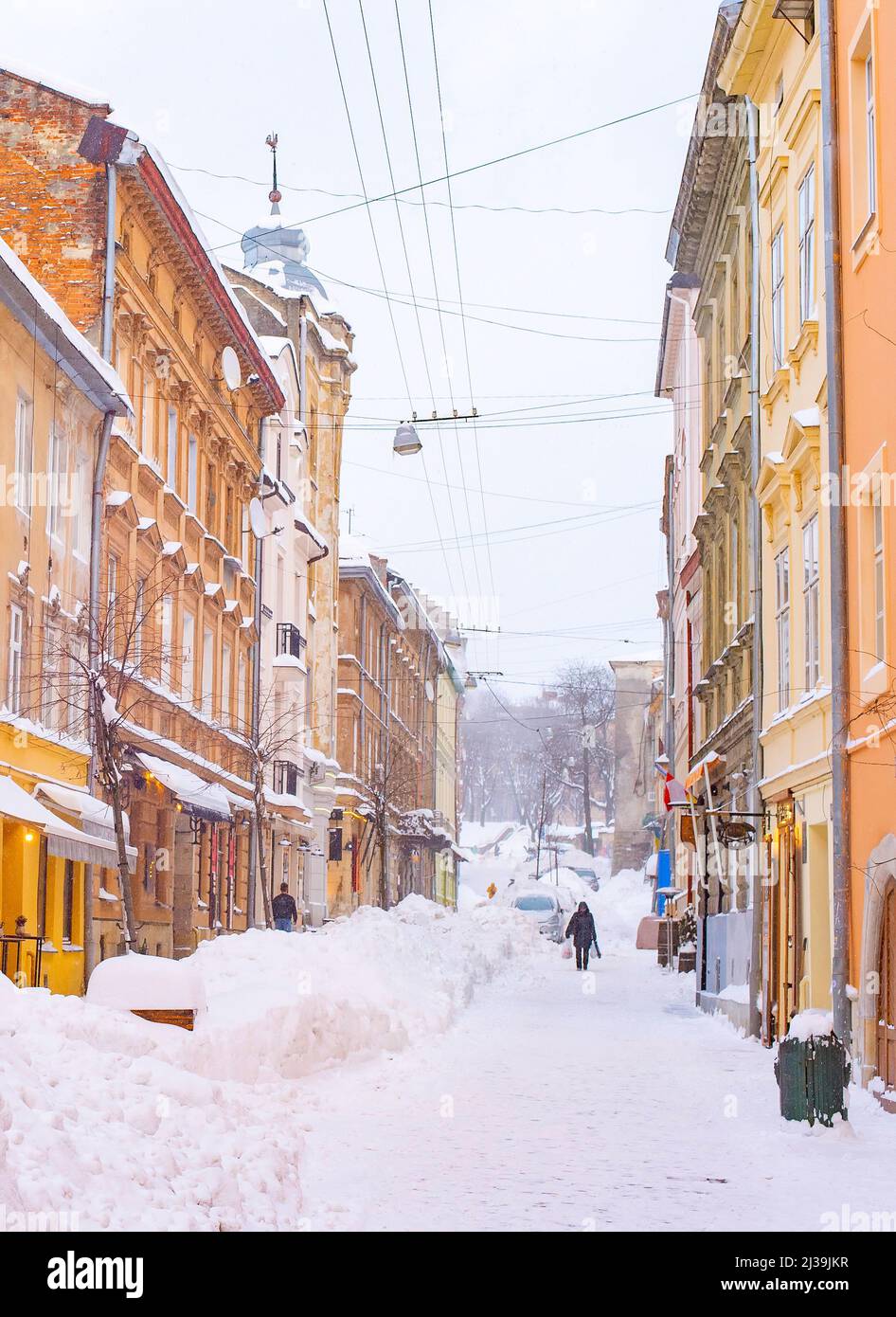 Snow covered street of Lviv old town with cafes and restaurants, winter Lviv cityscape, Ukraine Stock Photo