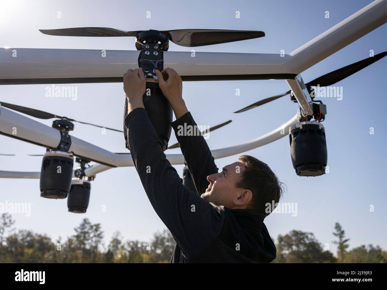 Elgin AFB, United States of America. 04 April, 2022. Brad Bollig, a LIFT team member, secures a battery to one of the Lift Hexa, electric, vertical takeoff and landing aircraft, before the first unmanned flight test via remote control at Elgin Air Force Base, April 4, 2022 in Elgin AFB, Florida. The aircraft, which used 18 motors and propellers, flew for approximately 10 minutes and reached a height of about 50 feet.  Credit: Samuel King Jr./US Air Force Photo/Alamy Live News Stock Photo