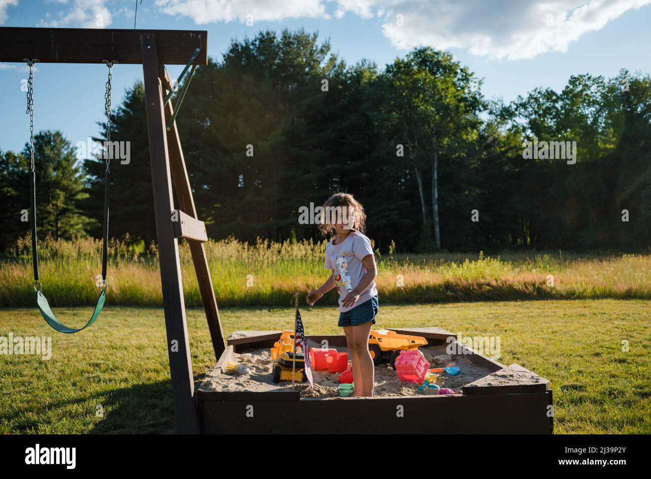 Young girl playing outside in sandbox Stock Photo
