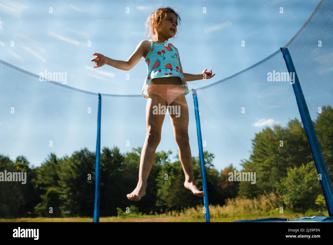 Young girl jumping on trampoline in air Stock Photo Alamy