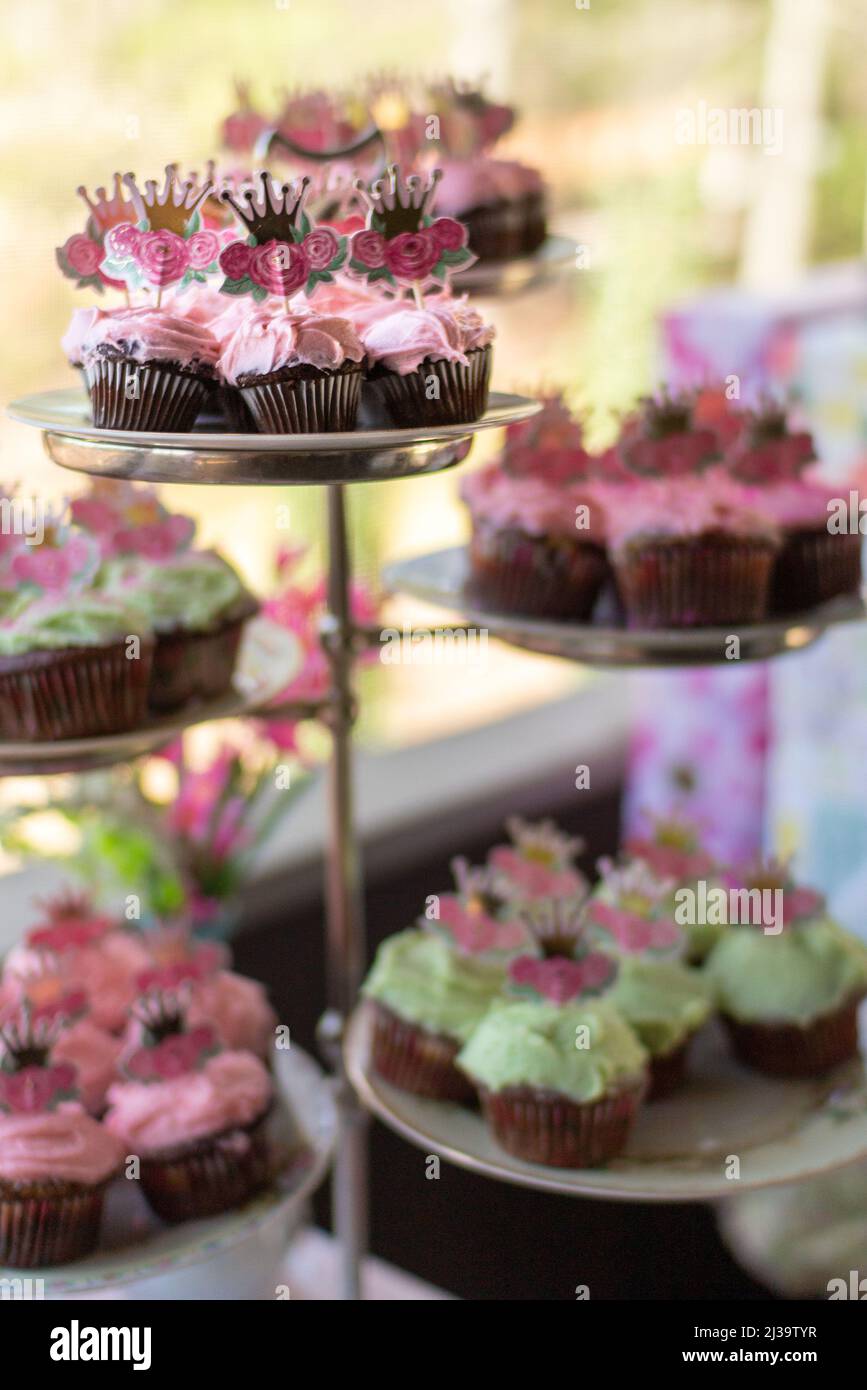 A cake stand holds decorated cupcakes at a baby shower. Stock Photo