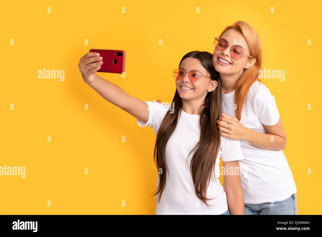 mom and kid bloggers. lovely woman and girl take selfie with smartphone. selfie family. Stock Photo