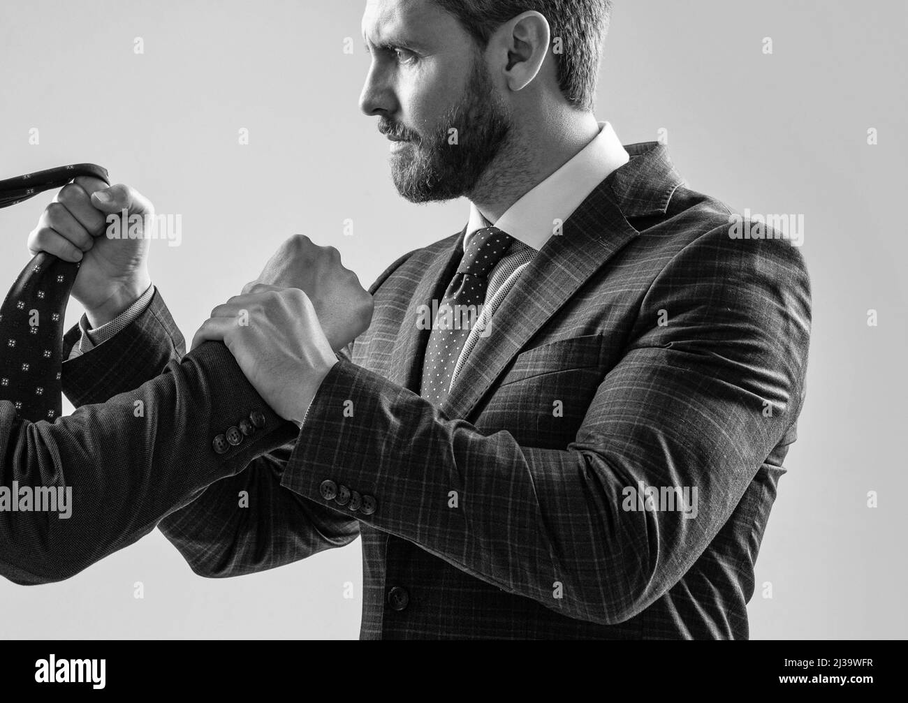Physical fighting between professional man and male employee grey background, confrontation Stock Photo