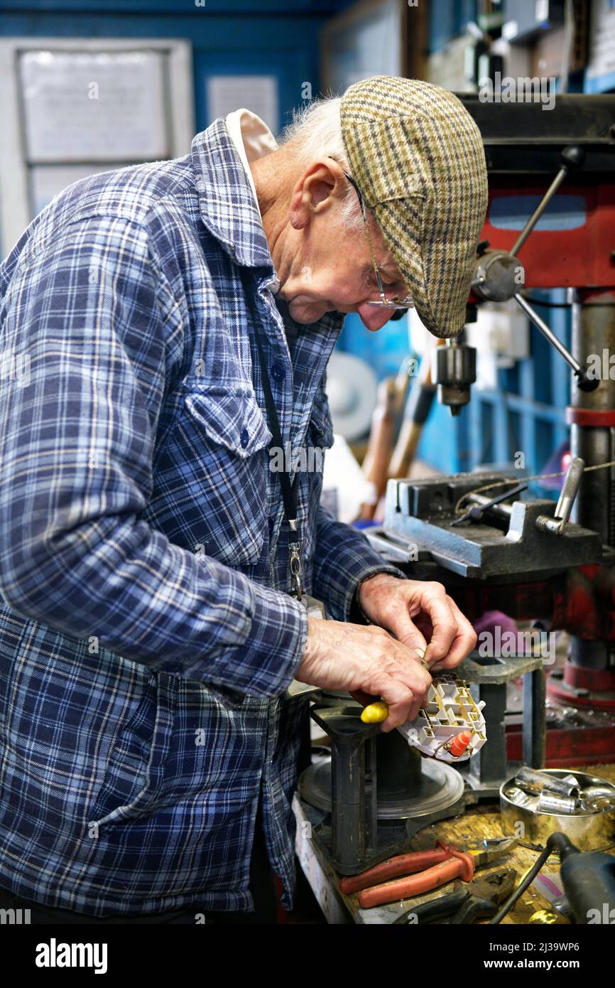 older man working at work bench Stock Photo