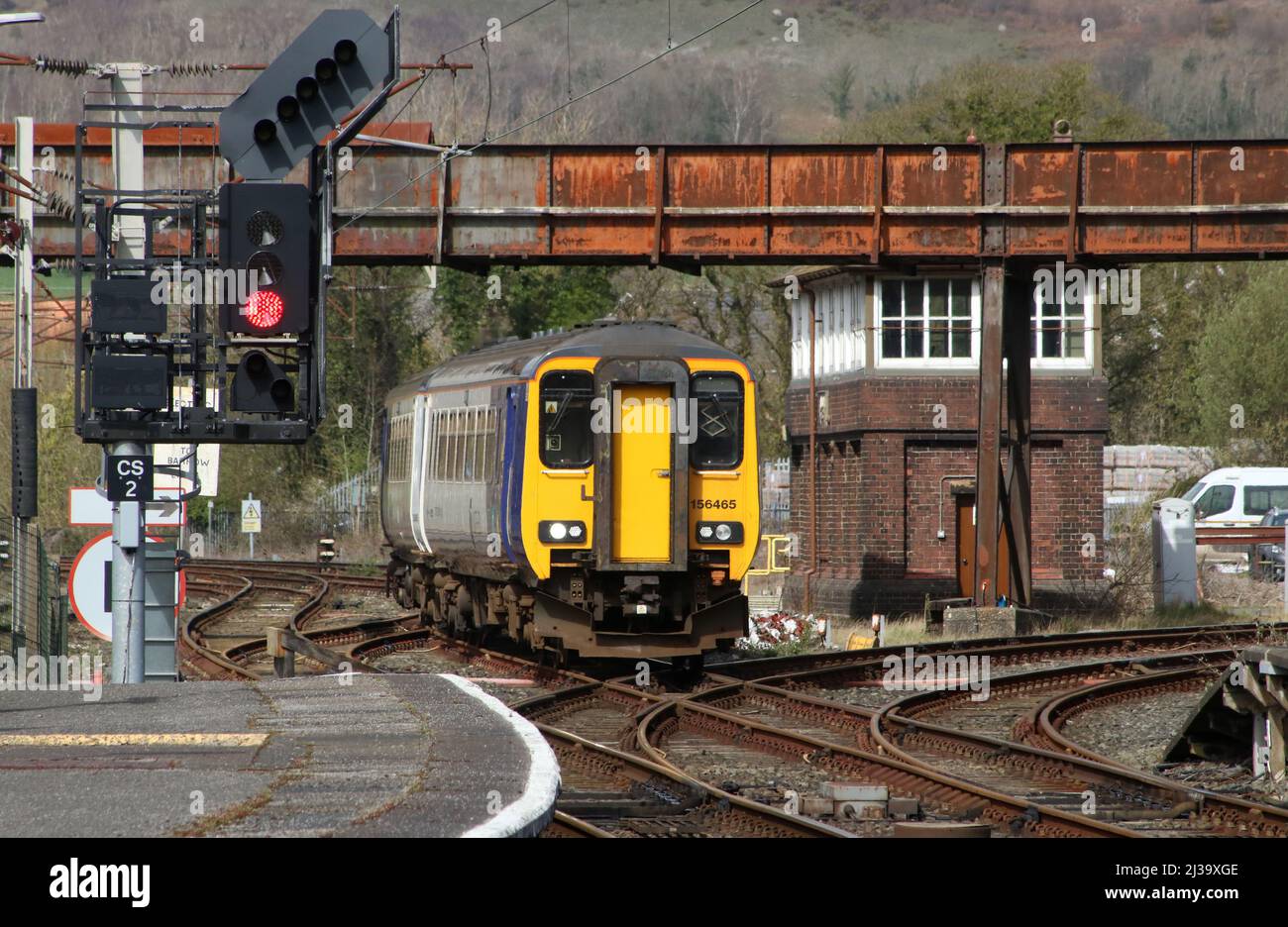 Northern Trains class 156 super sprinter dmu, unit number 156465, passing signal box and approaching Carnforth station on Wednesday 6th April 2022. Stock Photo