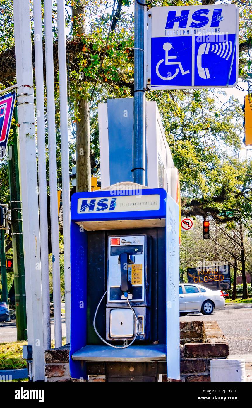 A coin-operated public telephone also called a payphone, stands on the corner of Government Street and Ann Street, March 26, 2022, in Mobile, Alabama. Stock Photo
