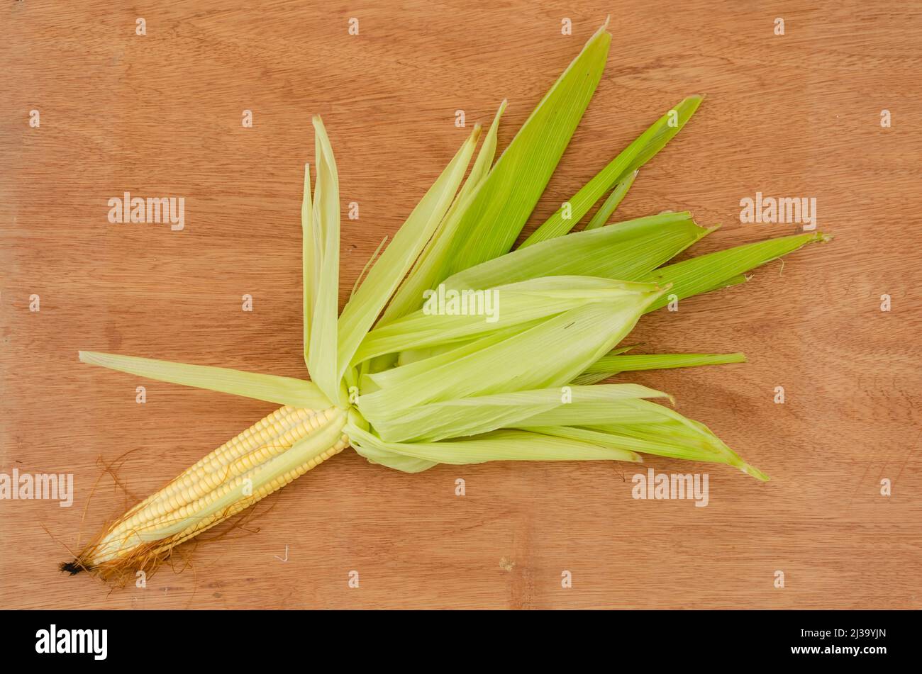 Yellow Corn On Cob With Husk On Board Background Stock Photo Alamy
