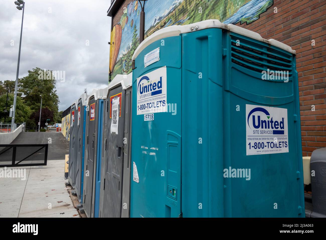 Woodinville, WA USA - circa September 2021: Street view of a line up of port-a-potties in the downtown area on a cloudy day. Stock Photo